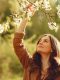 Ragazza che tocca una pianta in un ambiente naturale, simbolo di benessere e salute.