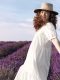 Bella donna sorridente in un campo di lavanda in fiore durante la primavera