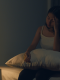 Donna con insonnia seduta a letto durante la notte