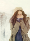 Donna con cappello e giacca pesante che si copre il viso dal freddo e dalla neve, simbolo della necessità di rafforzare le difese immunitarie nei primi freddi